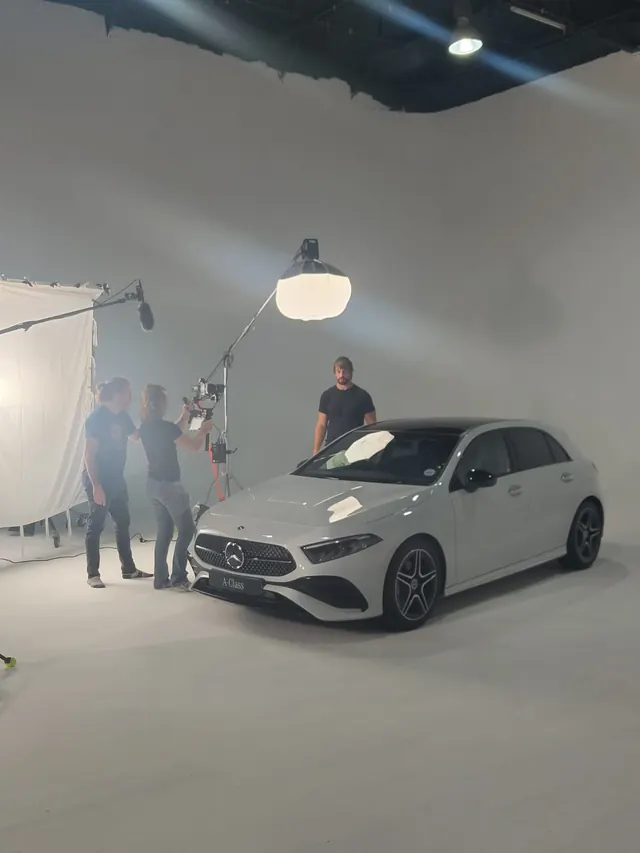 White hatchback on a lit studio set